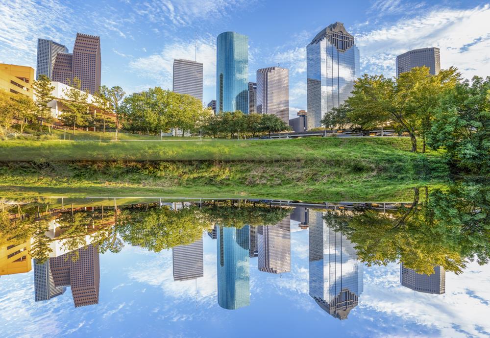 Scenic skyline of Houston, Texas in morning light seen from Buffalo Bayou Park and reflection in river